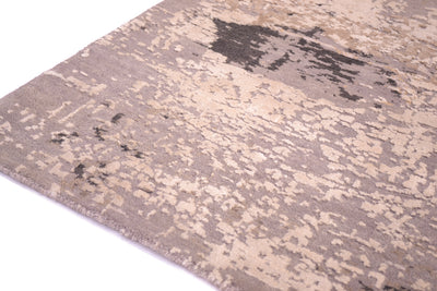 Detail of hadnwoven Indian Carpet with abstract design and charcoal grey wool  field and ivory light cream pure silk raised highlights.