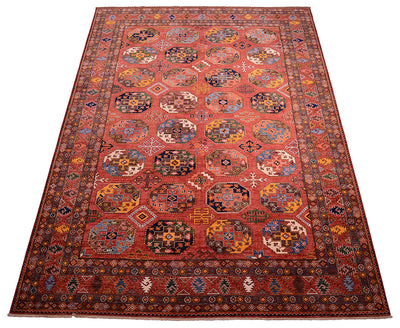 A 14x10 traditional hand-woven Afghan Ersari area rug with a rust field, featuring a repeating pattern of octagonal medallions and a detailed geometric border in shades of blue, yellow, black, and white.