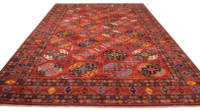 A traditional large hand-knotted Ersari carpet with a rust field, featuring intricate geometric medallion motifs and a detailed border in shades of blue, yellow, black, and white.
