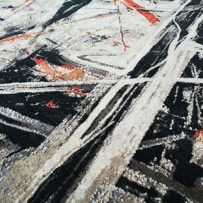 Close-up of Expression abstract handmade rug wool and silk fibres: grey, black, and red textured lines.
