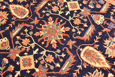 Close up detail of main field of Fine Ferahan carpet with pure wool pile. Deep rich midnight blue ground background of main field with interconnecting floral motifs of traditional floral design in contrasting colours.