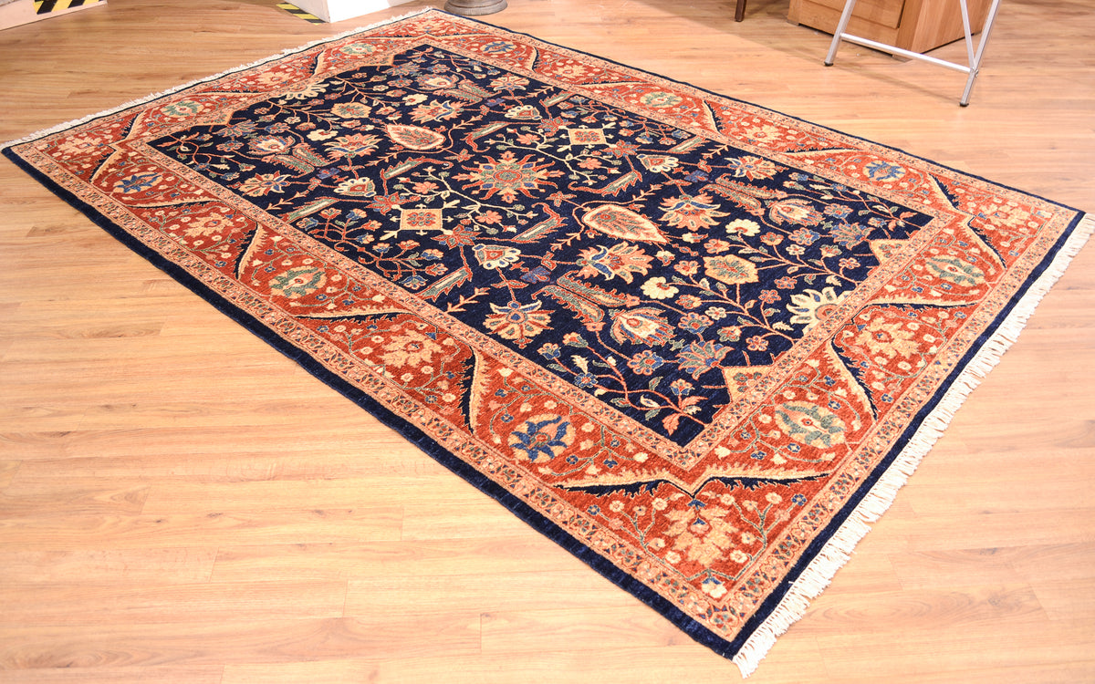 Fine Ferahan Carpet with dark blue background with contrasting floral pattern surrounded by a rust border with network of blossoms and meandering palmette and vine border patterning. 