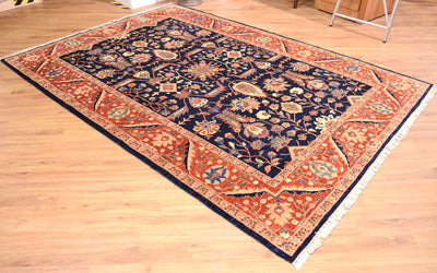 Fine Ferahan Carpet with dark blue background with contrasting floral pattern surrounded by a rust border with network of blossoms and meandering palmette and vine border patterning. 