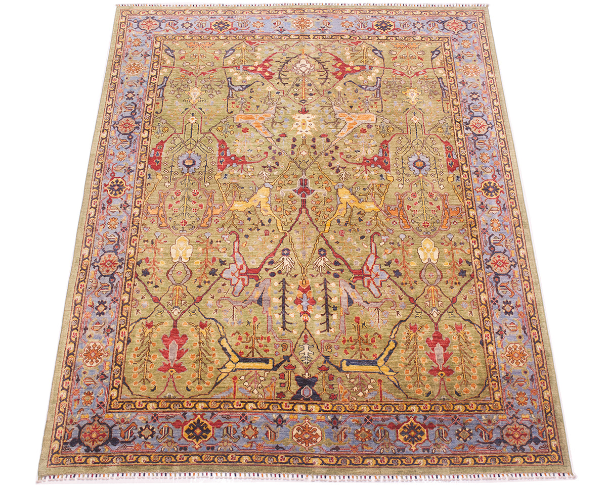 Overall view of handmade carpet with soft green field and blue background border. Cloudband traditional border with accents of gold yeloow, navy blue, red and light orange/ amber. 