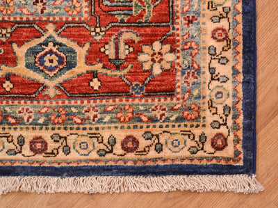 Corner detail of garous carpet with secondary colours of teal green and golden yellows. Floral meander minor borders encapsulatiing a traditional cloudband border design.