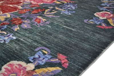 A close-up of a textured Afghan floral area rug with a dark green base and a vibrant floral pattern in pink, purple, red, and yellow.