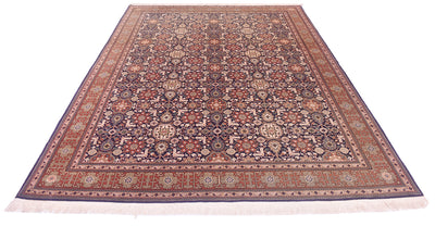 A rectangular  oriental Hereke rug with an intricate floral and geometric pattern in shades of navy blue, rust red, beige, and brown, shown flat against a white background.