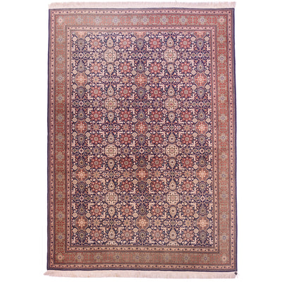 Faded Turkish old Hereke carpet with all over floral design set on a navy blue field.