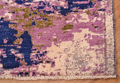 Corner detail of hand-knotted abstract Himalaya carpet with white cotton warp fringes and abstract design with pure wool pile and highlights of art viscose silk in creamy white.