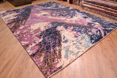 Angled view of large abstract carpet with mauve, blue ( dark and light) grey and creamy white of viscose art silk. Natural formations.