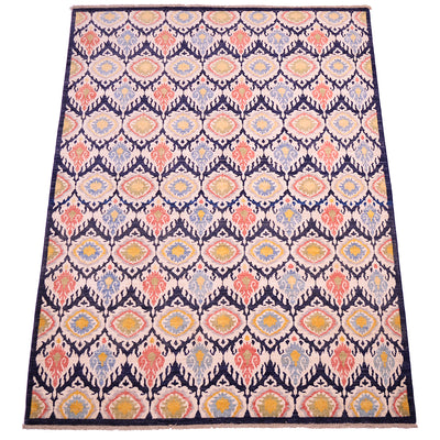 Overall view of Ikat design Carpet with cream, dark navy blue, terracotta coral, yellow gold, green as well as light blue. All over patterned design with pure wool pile.