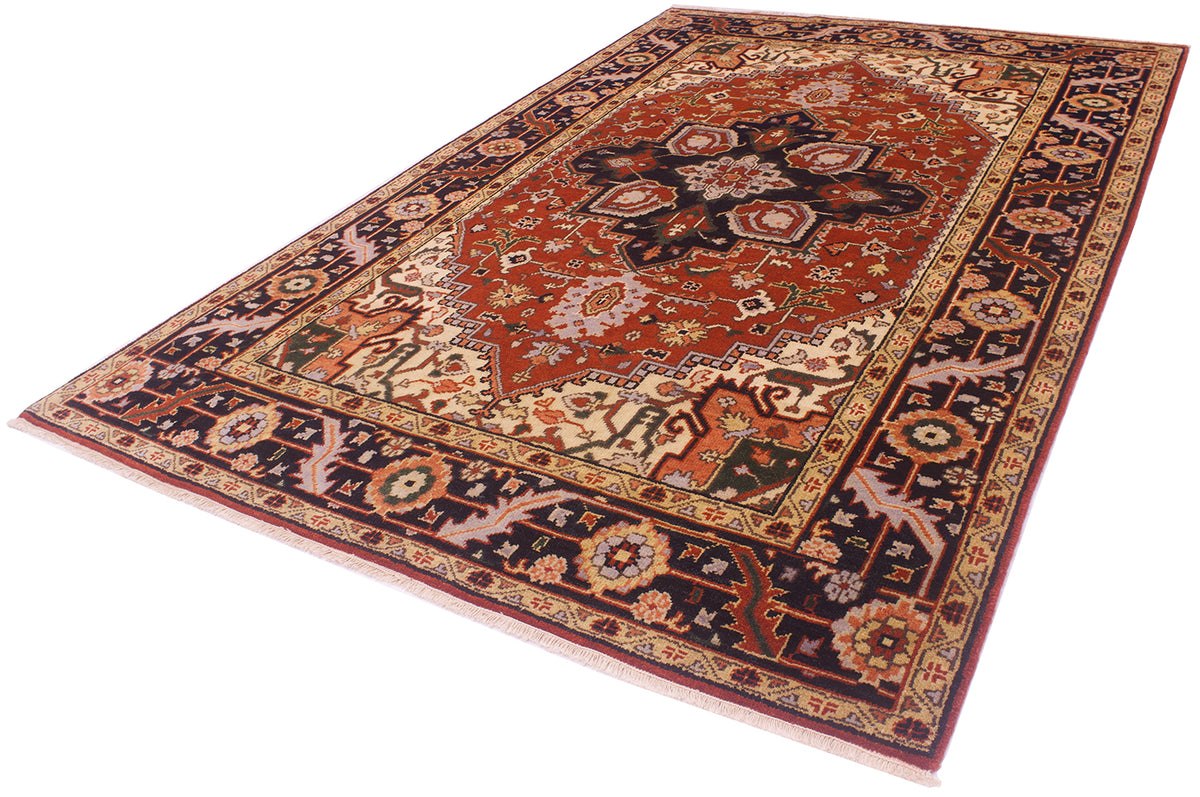 A traditional handmade Indo Heriz rug with a complex floral and geometric pattern, featuring a dominant rust-red center, dark navy borders, and accents of beige, green, and orange, shown on a plain white background.