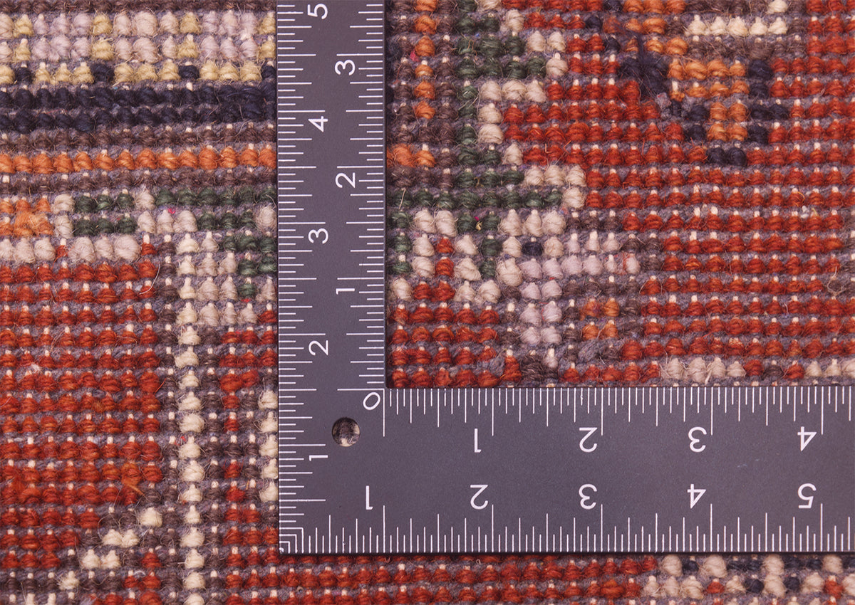 Close-up of the hand-knotted back of Indian Heriz rug with a dark gray L-square ruler placed over it to show scale, highlighting the woven texture and multicolour design.
