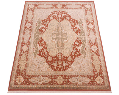 A traditional oriental-style area rug with an intricate floral pattern, featuring a central medallion and ornate borders in rust red, beige, and muted green tones.