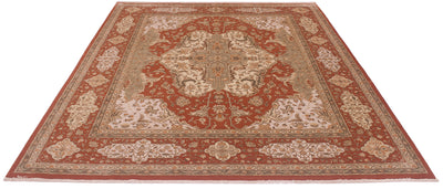 A traditional oriental area rug with an intricate floral pattern, featuring a central medallion and ornate borders in rust red, beige, and cream tones, shown from an elevated perspective against a plain white background.