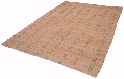 A rectangular woven rug with a warm tan and beige base, featuring a subtle plaid pattern in muted yellow, green, and gray tones, shown on a plain background.