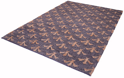 A rectangular area rug with a dark slate blue-gray base and a repeating tan abstract pattern, shown at an angle on a white background.