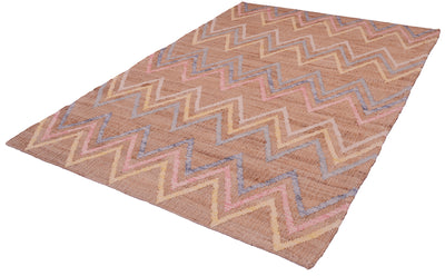 A rectangular woven area rug with a zigzag chevron pattern in shades of brown, beige, pink, and blue, shown at an angle on a white background.
