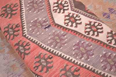  Detailed close up view of bench footstool with vintage turkish kilimmade from a central medallion from a large kilim with terracotta, cream, mauves, greys and chestnut browns. Handmade variations in colour a handmade kilim