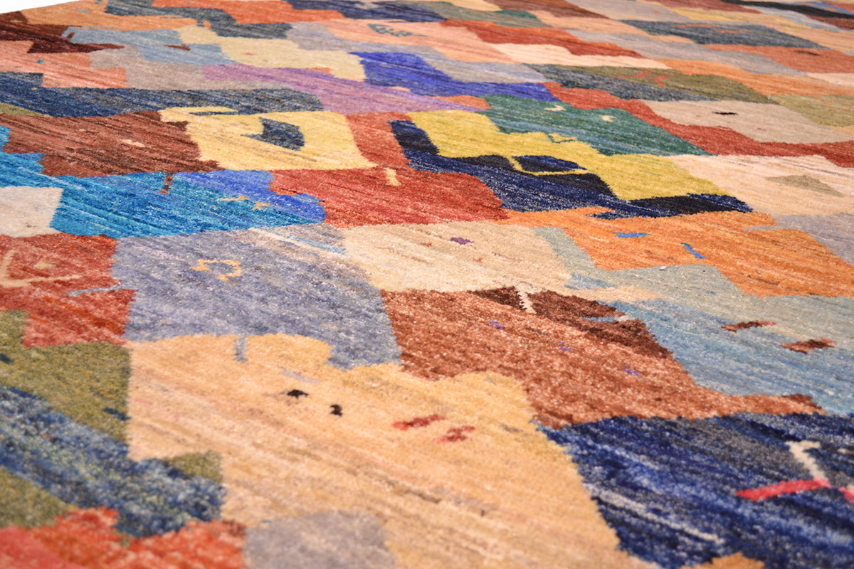 Vibrancy of colours of handmade Afghan Carpet with interlocking forms of various hues and tonalities. Pure wool handknotted pile.
