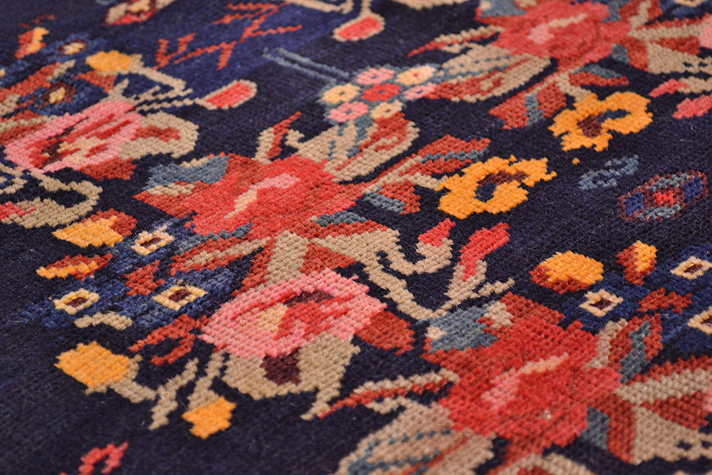 Fine knotting and close up of main field of antique karabagh antique floral rug with pink, rose, blue, yellow and light green with floral sprays and leaf flowers.