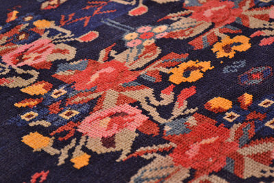 Fine knotting and close up of main field of antique karabagh antique floral rug with pink, rose, blue, yellow and light green with floral sprays and leaf flowers.