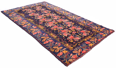 Angled view of Antique Karabagh carpt with gul farang design with blue gorund border and deep blue black field. Placed on a white background. Roses and rose leaves border with intricate scrolling vines inner border.....All over floral design with naturalistic clours. 
