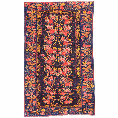 Antique Karabagh rug with floral design set against a blue-black ground deep indigo ground. Multipled floral spray in main field and border, scrolling vine inner border in golden ochre.