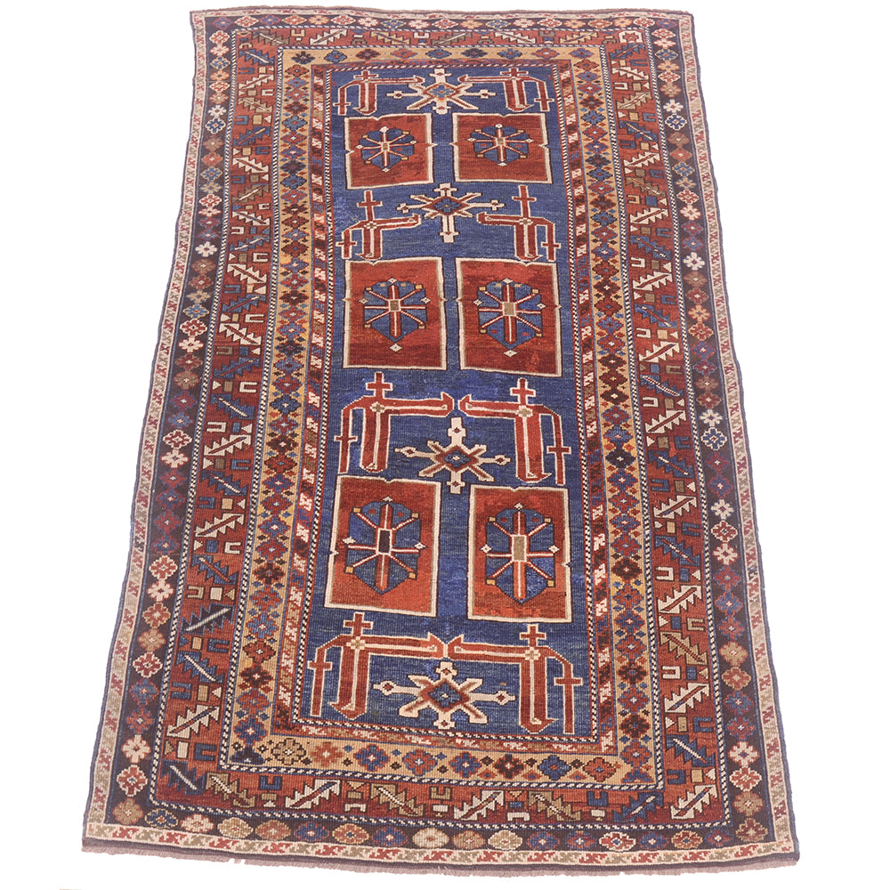 A traditional antique rectangular Caucasian Karagashli wool rug dating from circa 1900 with a complex geometric pattern, featuring a dark blue central field, rust-red squares, and cream accents, bordered by intricate geometric motifs.