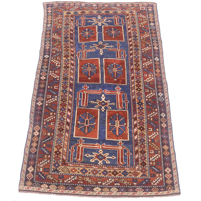 A traditional antique rectangular Caucasian Karagashli wool rug dating from circa 1900 with a complex geometric pattern, featuring a dark blue central field, rust-red squares, and cream accents, bordered by intricate geometric motifs.