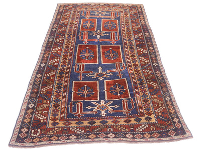 A traditional hand-knotted geometric antique Caucasian Karagashli rug with a dark blue field, red-orange central panels, and beige borders, shown flat against a white background.