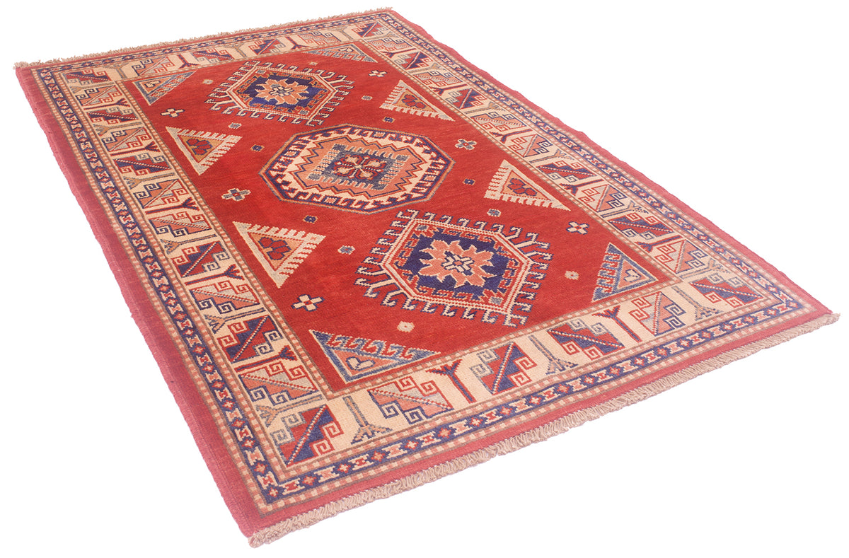 Red handmade Kazak rug laid flat with geometric motifs and decorative border