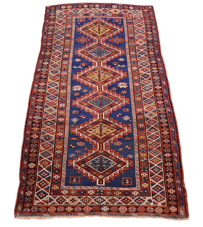 Overall views of antique kazak ling rug with mulitoclours an ruch blue fields with six interconnecting stepped medallions and multiple geometric borders. Colours of red, blue, golden yellow, teal and black. 