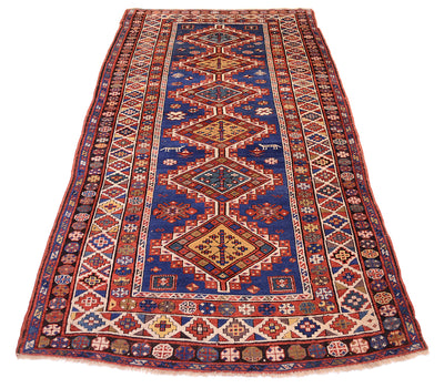 Overall views of Antique kazak carpet with blue firlds and six connecting medallions centre with multicoloured palette and multiple geometric borders. Stunning array of primary and secondary colours. 