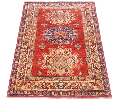 A rectangular traditional oriental Afghan Kazak design rug with a vibrant rust-red field, featuring two large central medallions in blue, beige, and red, surrounded by a detailed geometric border.