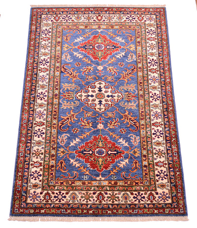 A traditional handmade Fine Kazak wool Rug with a blue central field, red and beige medallions, and a detailed multicolor border, shown flat against a white background.