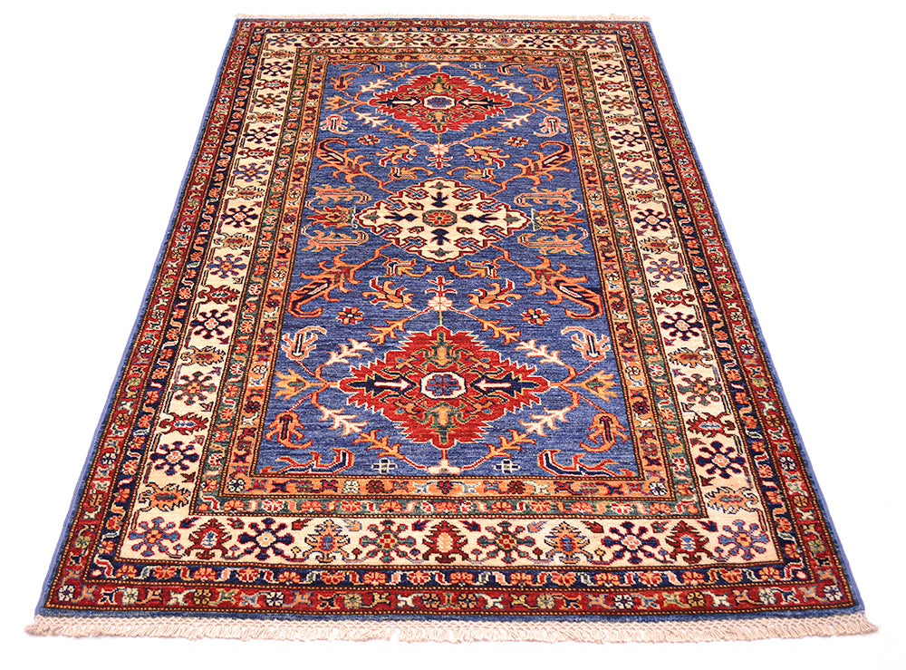 A traditional Kazak design area rug with a blue field, red and beige medallions, and intricate floral borders, shown flat against a white background.