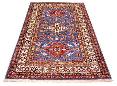 A traditional Kazak design area rug with a blue field, red and beige medallions, and intricate floral borders, shown flat against a white background.