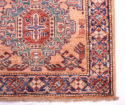 A close-up of a traditional Fine Kazak Peach colour Handmade runner corner showing a peach field with red, blue, and green geometric motifs and fringed edges.