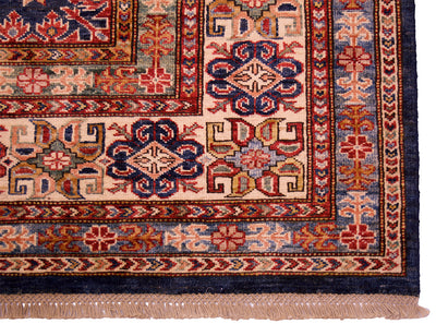 Lower border close-up of navy kazak rug with red, blue, and cream trims