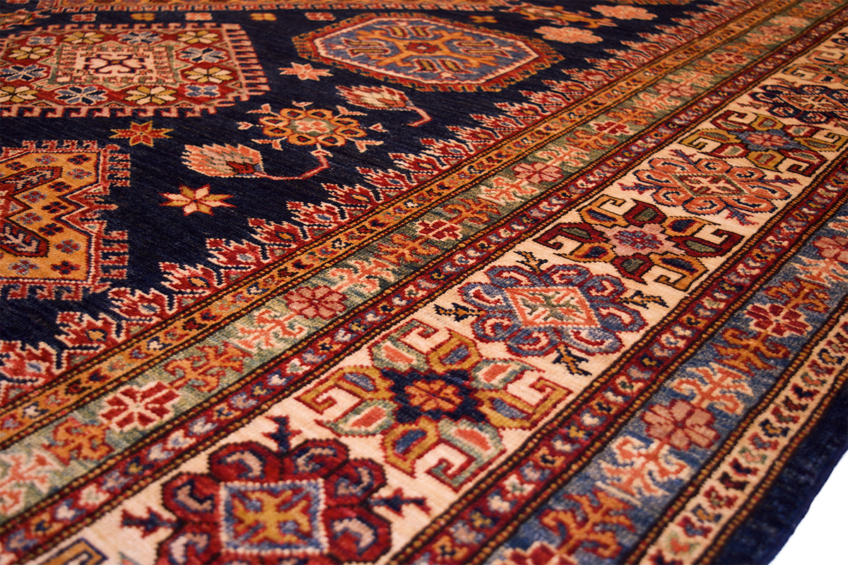 Diagonal close-up of navy kazak rug border with multicolor vine and medallions