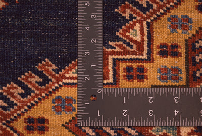 Navy kazak rug texture close-up beside measuring ruler for scale