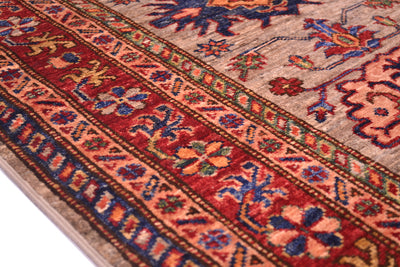 A close-up of a traditional patterned Afghan Kazak Runner showing detailed woven motifs in red, blue, grey, and orange.