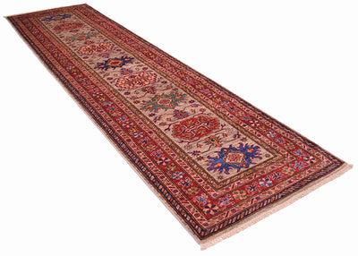 A long rectangular Kazak Runner rug with an intricate traditional pattern in red, blue, green, and grey, shown on a plain white background.