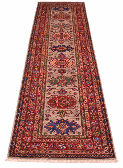 A traditional long Kazak runner rug with an intricate pattern, featuring a grey centre field, red borders, and blue and green medallions, shown flat against a white background.