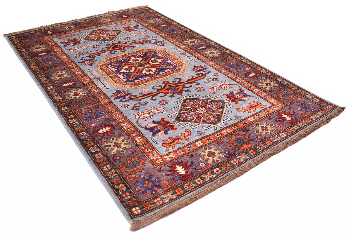 A fine light blue Afghan Kazak rug in an angled position on a white background