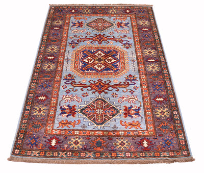 A traditional oriental-style fine Afghan Kazak area rug with a light blue field, red and aubergine borders, and multicoloured geometric motifs, shown flat against a white background.