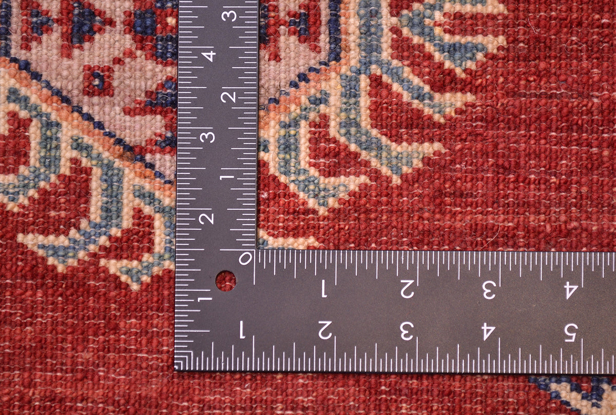 Close-up of the knotted back of a Large handmade red fine Kazak carpet with a metal L-shaped ruler placed on it to show scale, highlighting the red, beige, and blue woven design.