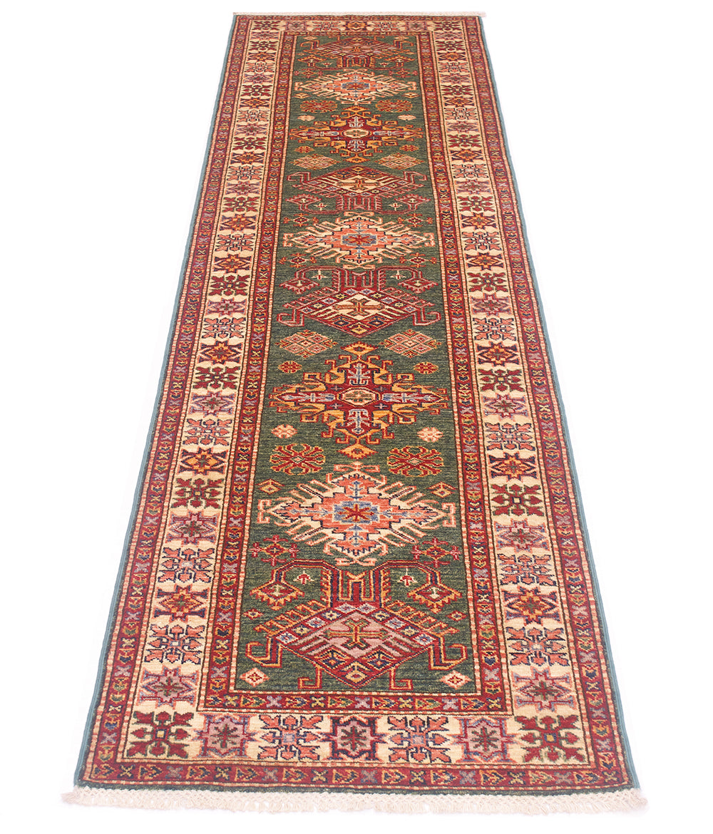 A long rectangular Kazak hallway Runner with an intricate traditional pattern, featuring a central green field, red and beige medallions, and a patterned border, shown flat against a white background.