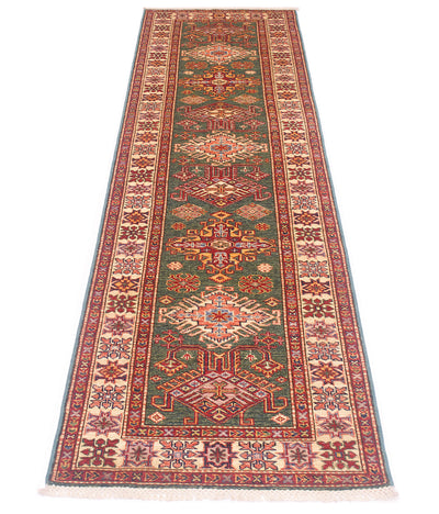 A long rectangular Kazak hallway Runner with an intricate traditional pattern, featuring a central green field, red and beige medallions, and a patterned border, shown flat against a white background.